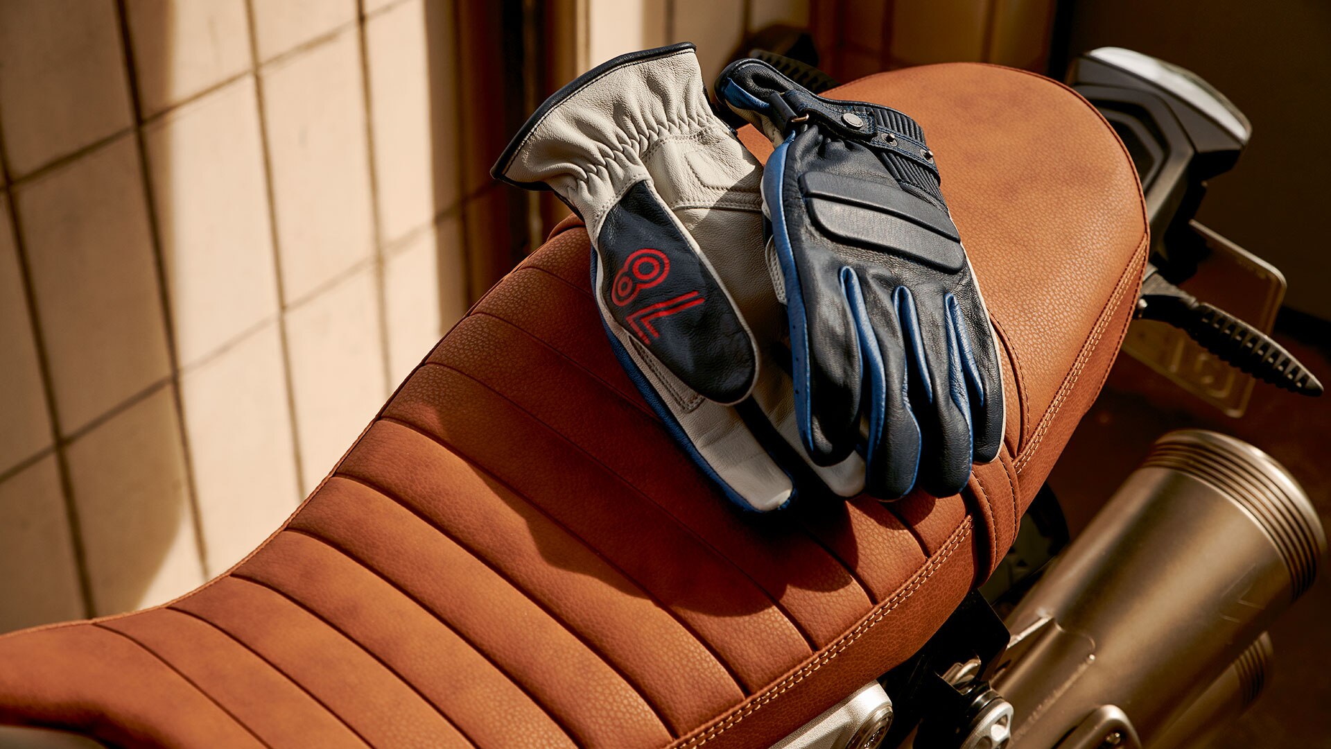 Leather gloves "40 Years" Limited Edition, based on the Rockster gloves lying on a motorcycle seat