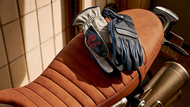 Leather gloves "40 Years" Limited Edition, based on the Rockster gloves lying on a motorcycle seat