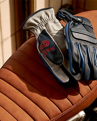 Leather gloves "40 Years" Limited Edition, based on the Rockster gloves lying on a motorcycle seat